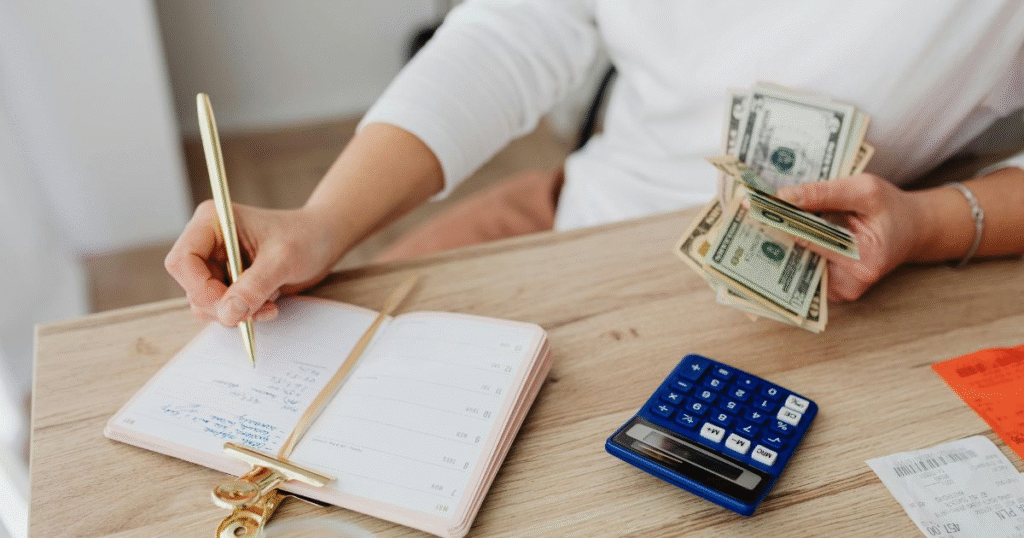 A person counting cash and planning finances with a calculator. Illustrating budgeting tips for beginners.