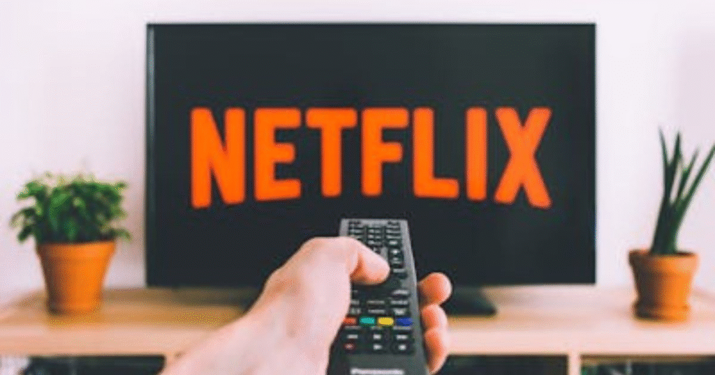A picture showing a person holding a remote in front of a tv showing the importance of saving for entertainment.