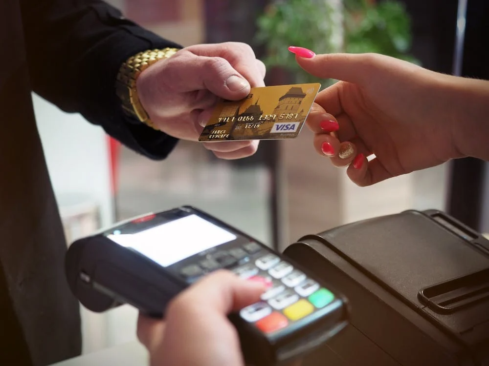 Man managing finances and automating savings using credit cards with the 50/30/20 rule.