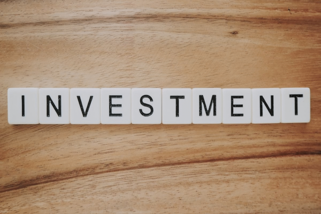  Scrabble tiles spelling “Investment,” showing how couples manage finances in marriage for future growth.