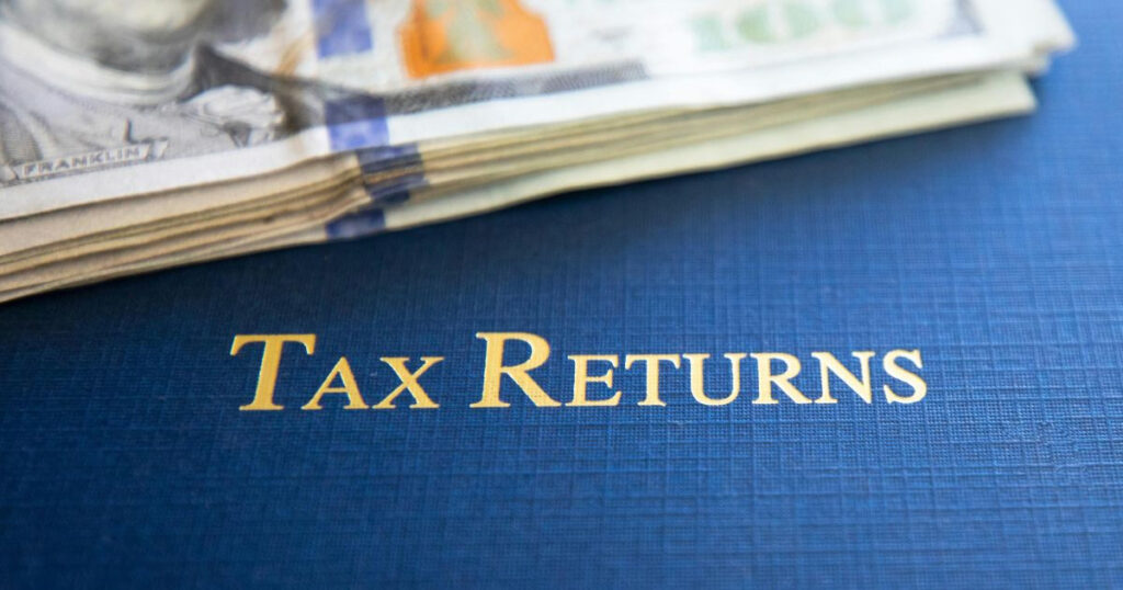 Alt text: Dollars and a folder with “Tax Returns, “ which are important when filing taxes