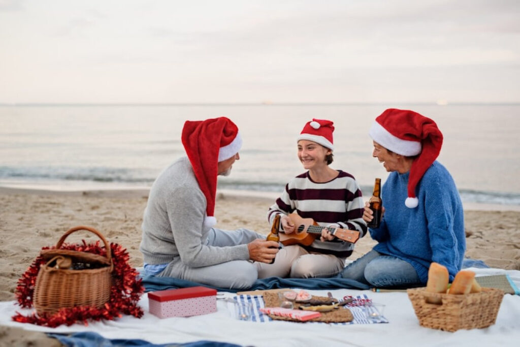 A picture showing a happy senior couple with granddaughter sitting on blanket and having picnic outdoors