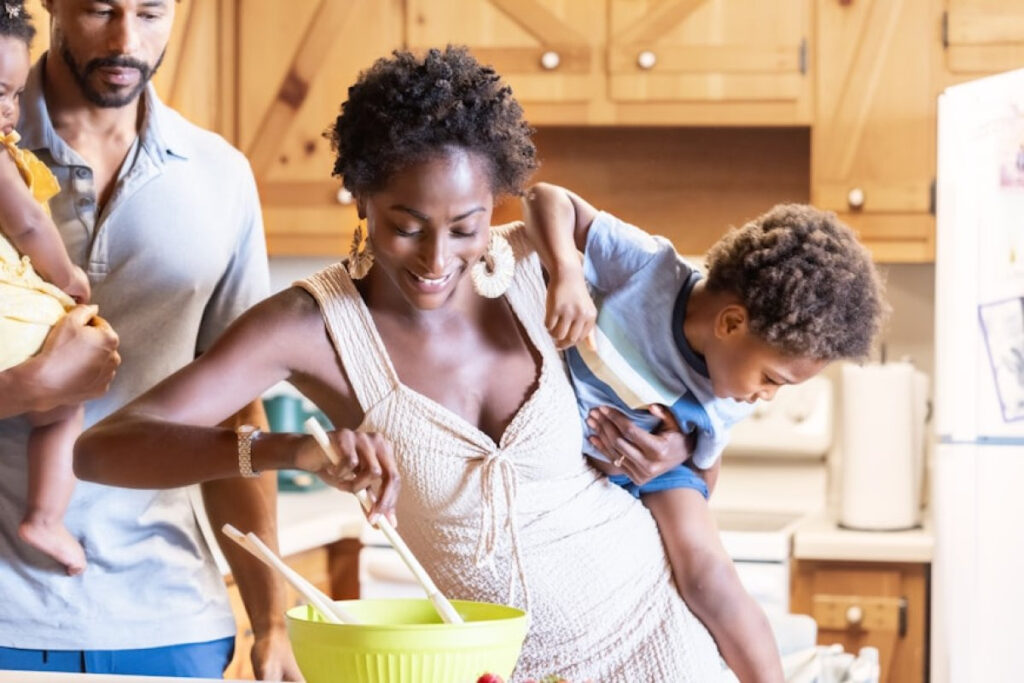 A picture showing a family cooking together in a bright kitchen, the perfect way of celebrating Christmas on a budget,