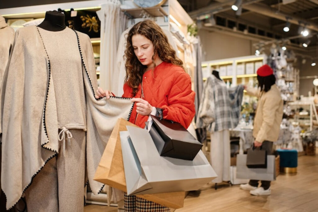A woman looking at a shawl jacket in a cloth store