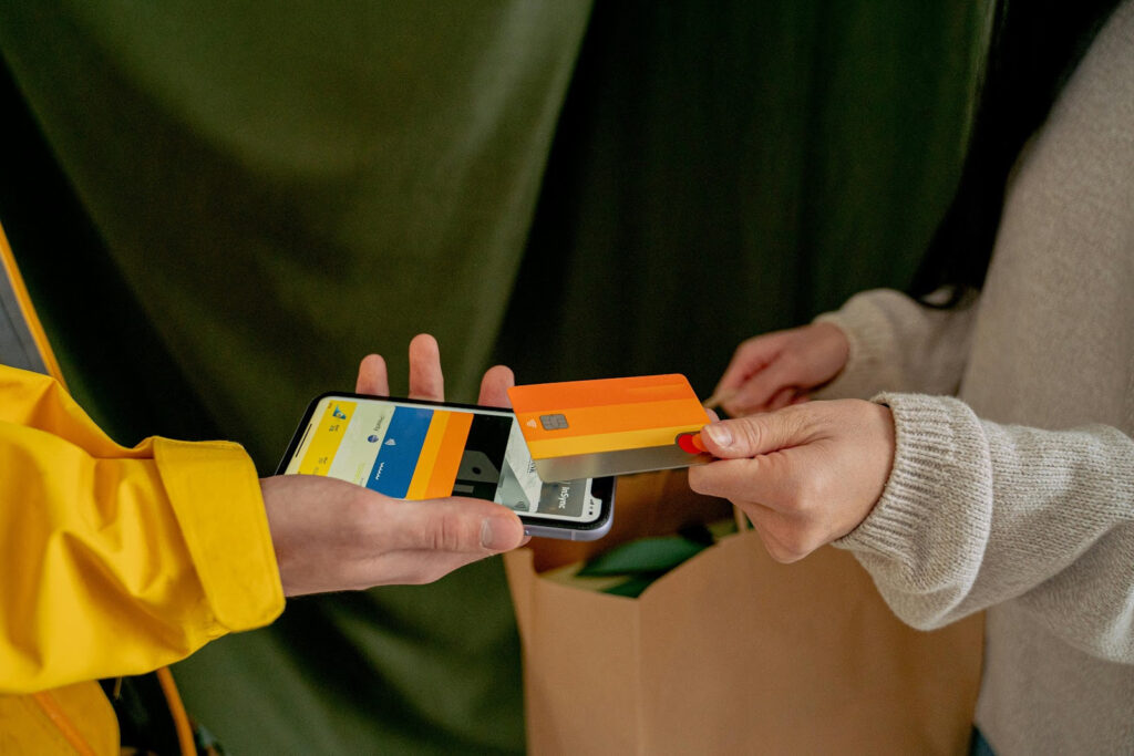 A woman paying with a credit card, showing one of the budgeting mistakes to avoid with automatic bill payments.