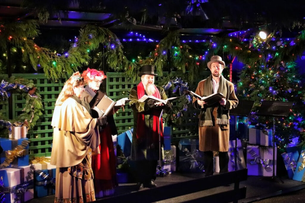 An image showing a group of people singing a Christmas carol. One way of celebrating Christmas on a budget.