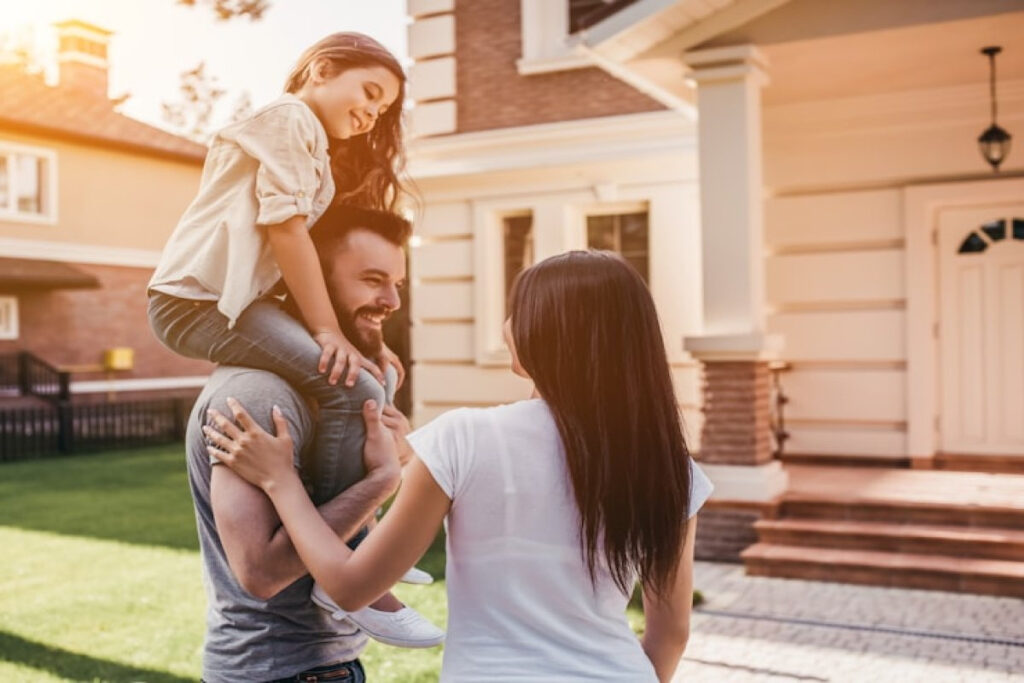 Picture showing a Happy family smiling near their modern home.