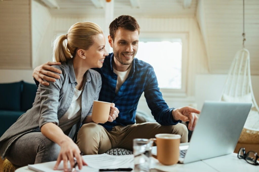 A picture showing young couple discussing finances while working on a laptop, showing financial transparency in relationships.