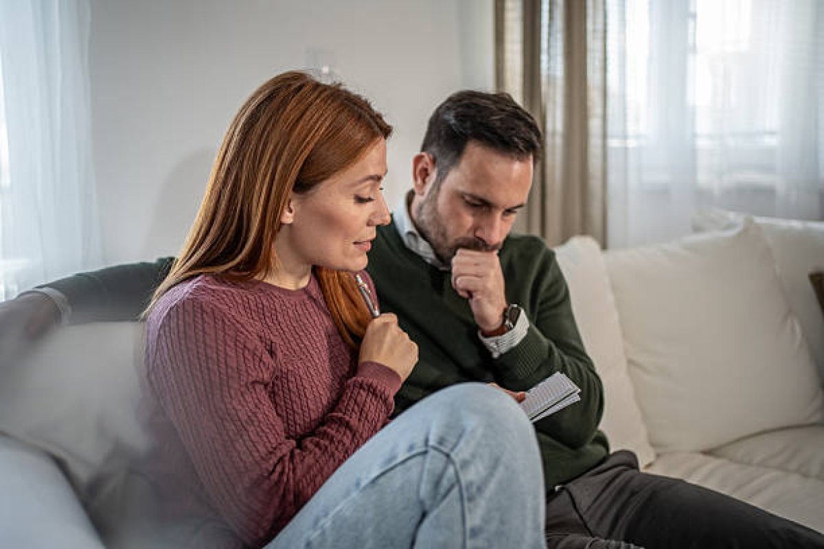 A picture showing a couple writing down financial goals, showing how to discuss money with your partner calmly and collaboratively.