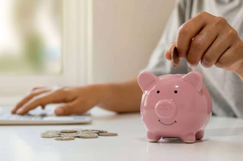 An image showing someone splitting their bills and expenses in a piggy bank
