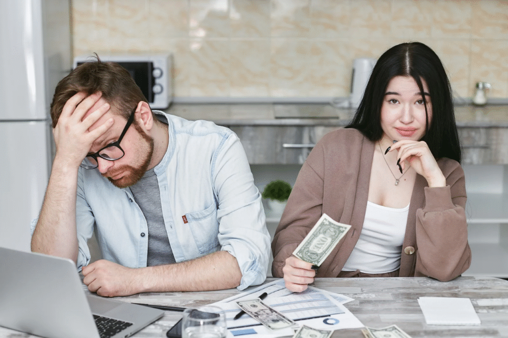 An image showing a man and woman sitting in front of a table with money