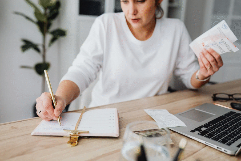 A picture showing A person reviewing their finances at a desk with a laptop and notebook after finding out their partner has a lot of debt