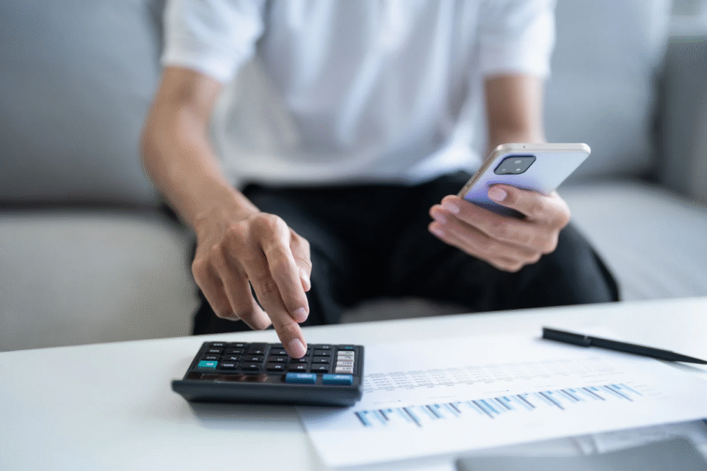 A picture showing a man at a table, writing down shared expenses in a notebook and calculating a joint budget together.