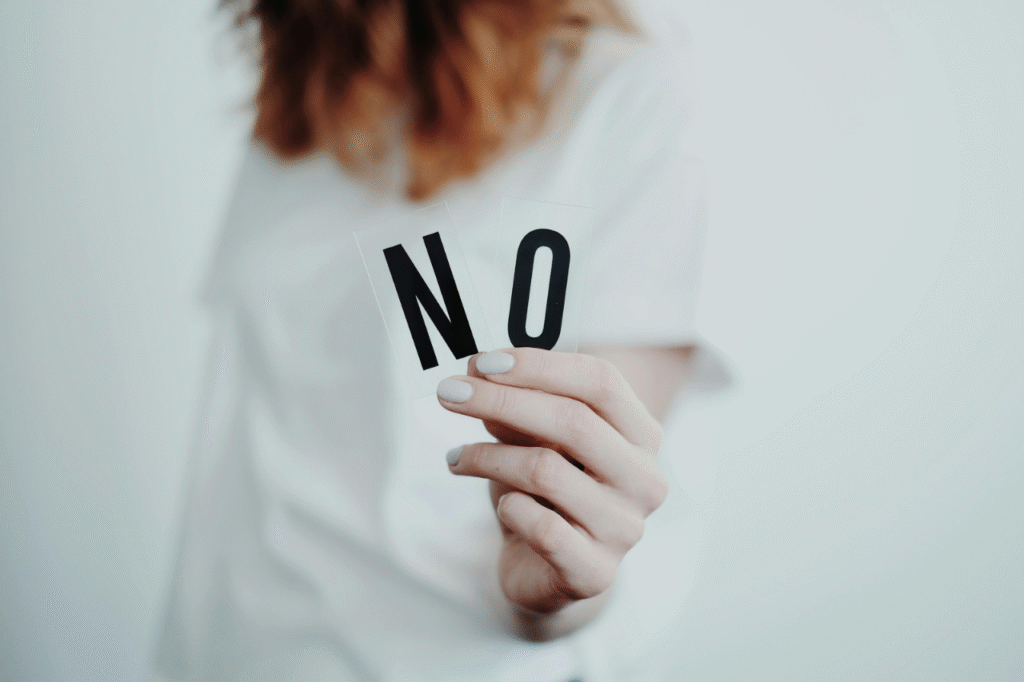 An image showing a lady holding a no sign. One of the ways to limit financial red flags in a relationship