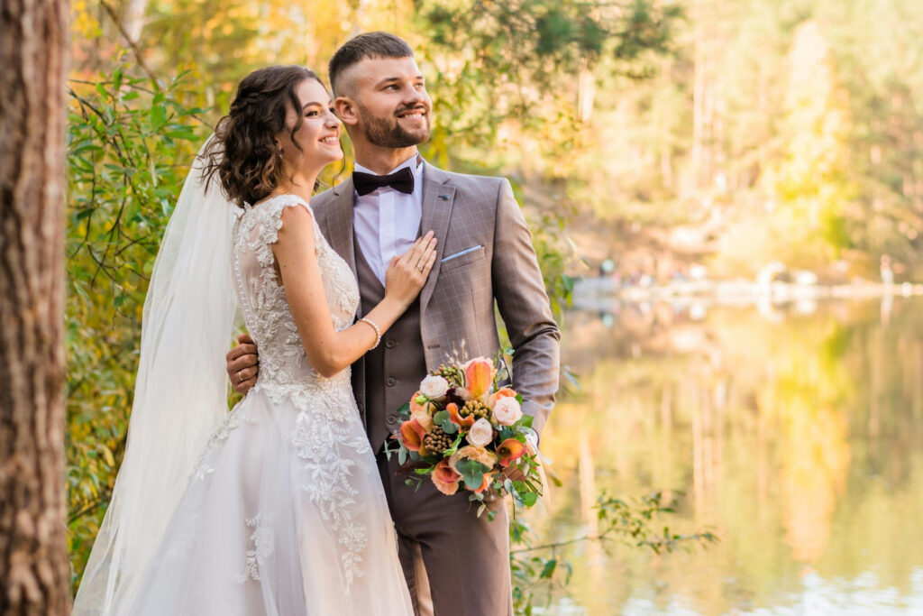 An image showing Newly married couple outdoors on their wedding day, representing the traditional path of marriage before buying a home together.