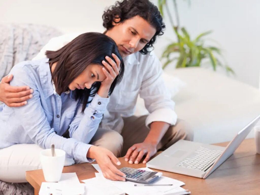 An image showing An image showing a couple calmly going through financial distress together. This shows how to protect yourself from a financially irresponsible partner