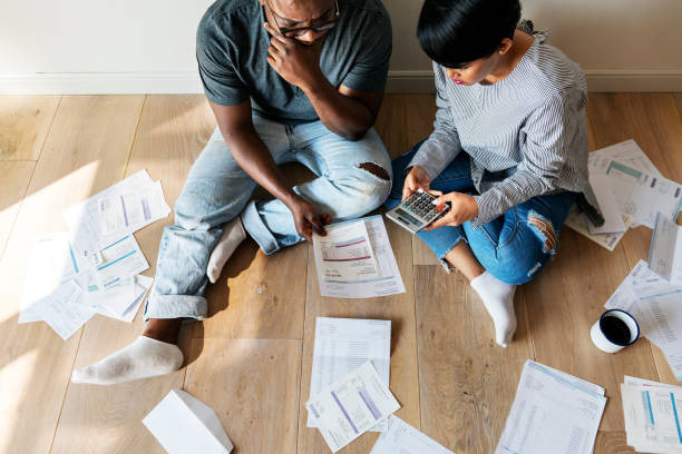 An image showing a couple reviewing bills and creating a tighter budget while living below their means