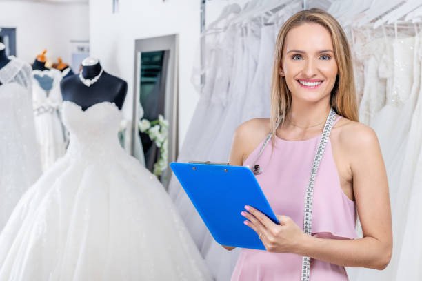 An Image showing a wedding dress consultant helping a bride choose a gown while managing wedding expenses and save for a wedding as a couple.