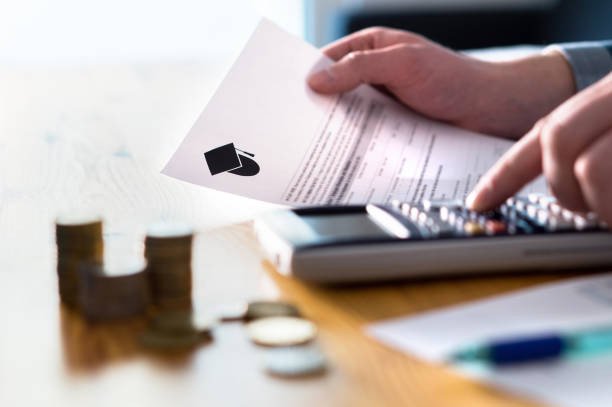 An image showing Hands calculating bills and expenses with coins and a calculator, illustrating budgeting strategies used for paying off student loans as a couple.
