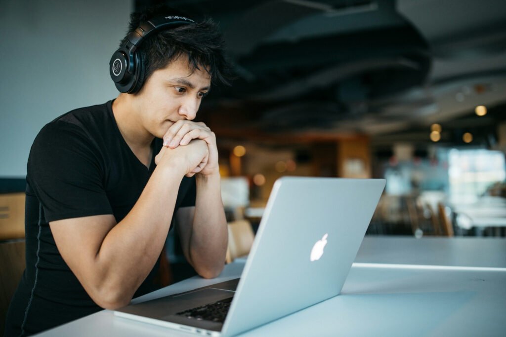 An image showing A young man concentrating on his laptop late at night, representing the hard work and discipline needed to pay off student loans as a couple.